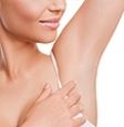 Eine Frau hebt ihren Arm um eine Haarwuchsreduktion zu verdeutlichen